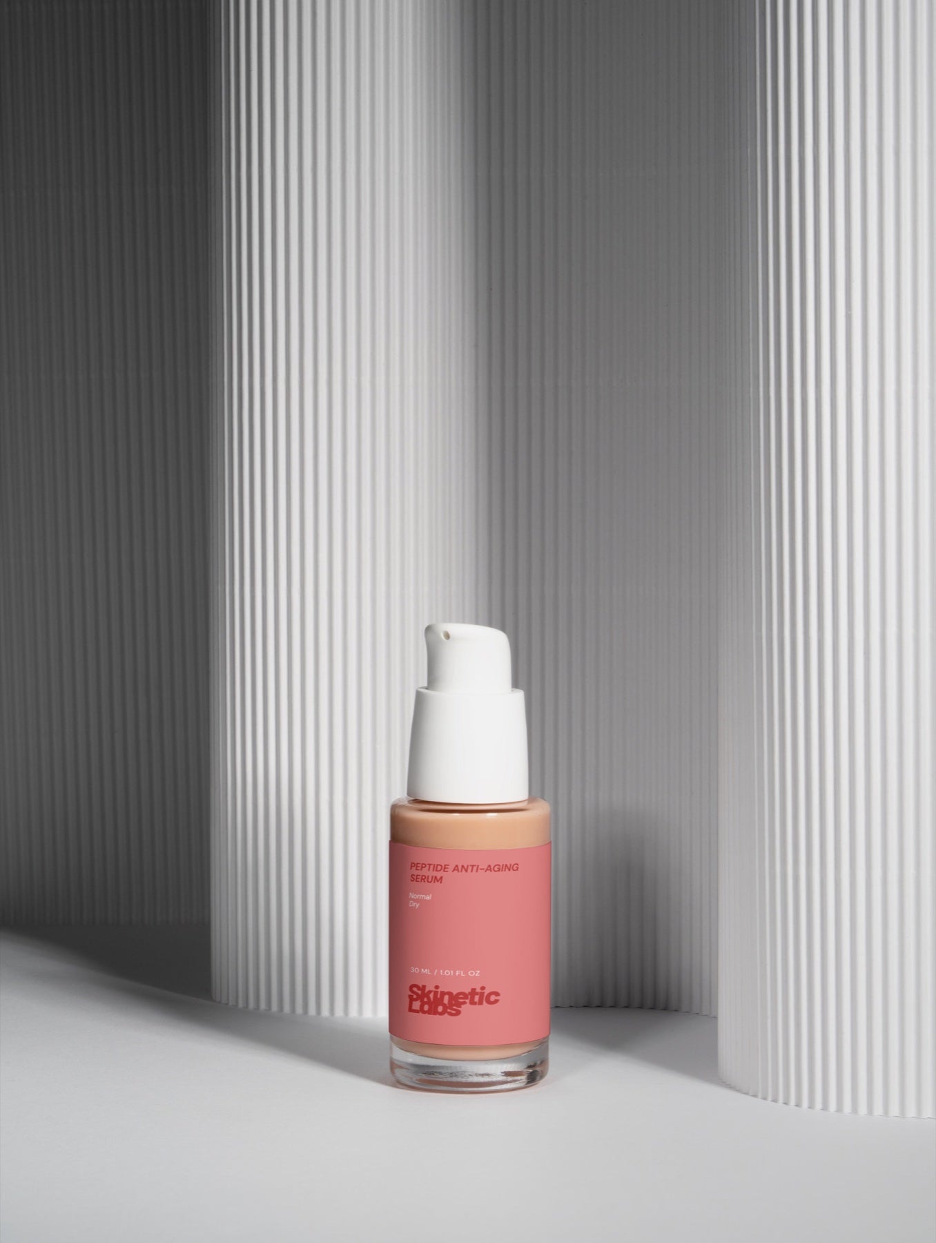 Skinetic Labs peptide serum against a sculptural background